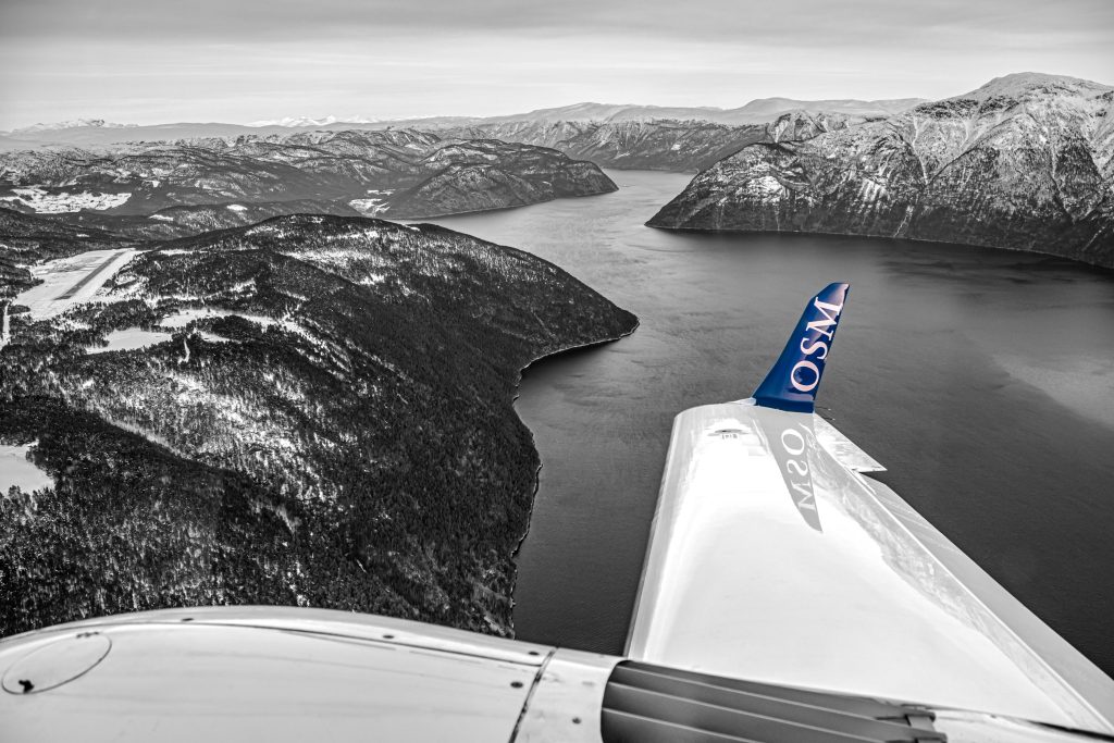 Plane flying above water and mountain