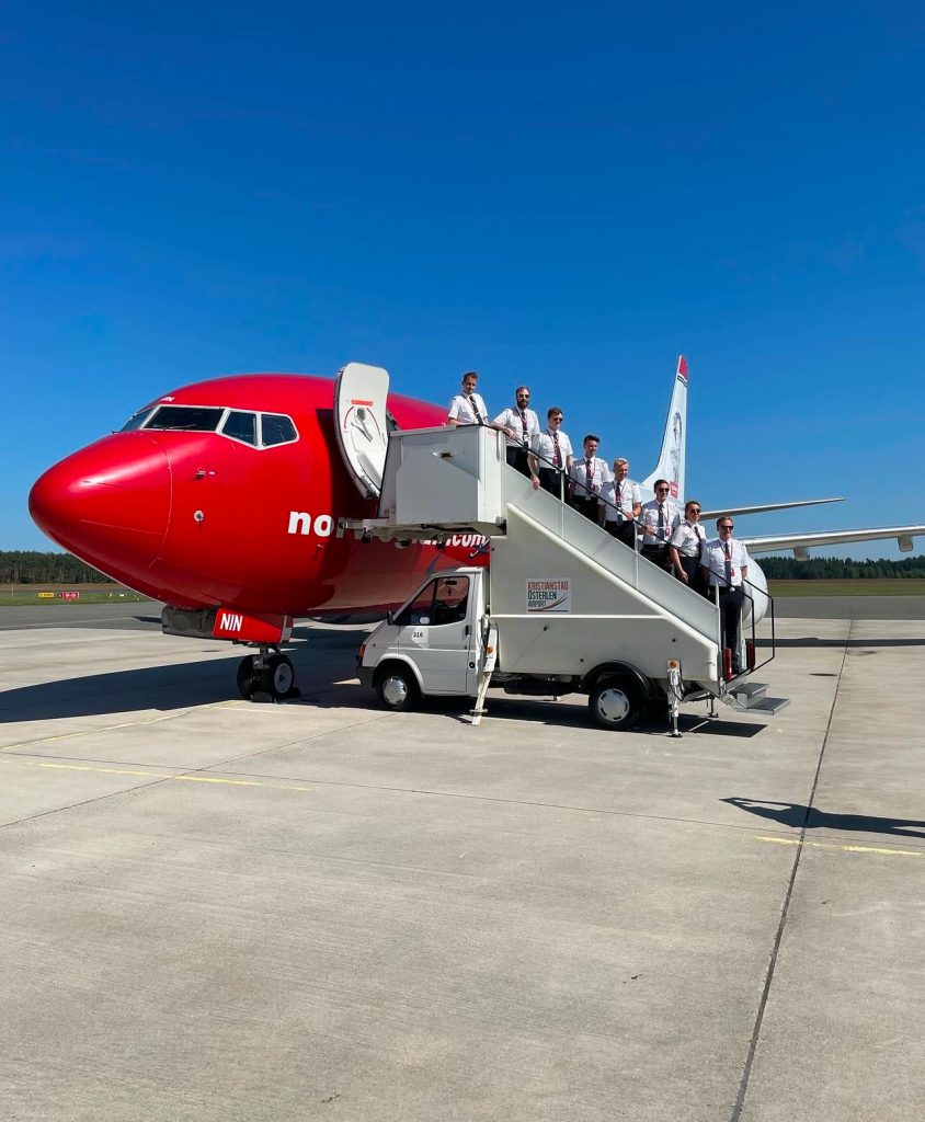 Alumni in front of Norwegian aircraft