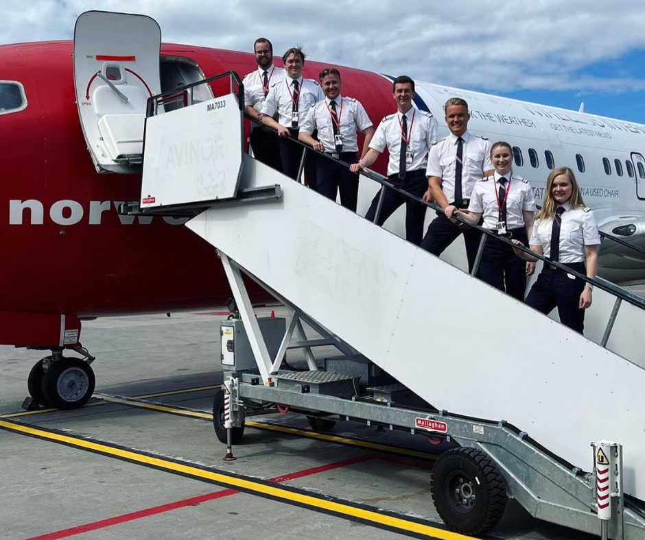Students standing on stairs to norwegian plane