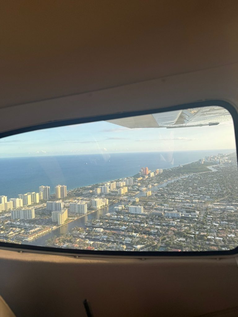 Window of Cessna flying over Miami